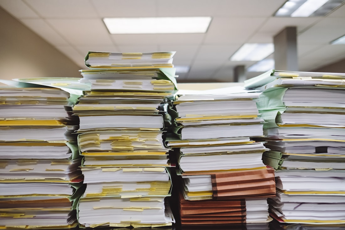 机の上に高く積み上がった大量の書類